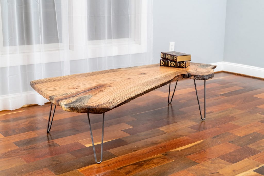 red oak live edge coffee table with two books in living area
