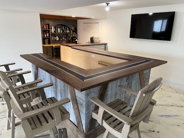 Black walnut bar top with a blue epoxy river, built by Makers Woodshop